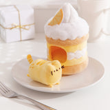 Side view of the Lemon Plush. The removable interior plush rests in front of the cake environment. The little yellow plush has zest squiggles on the booty area of the cat.  