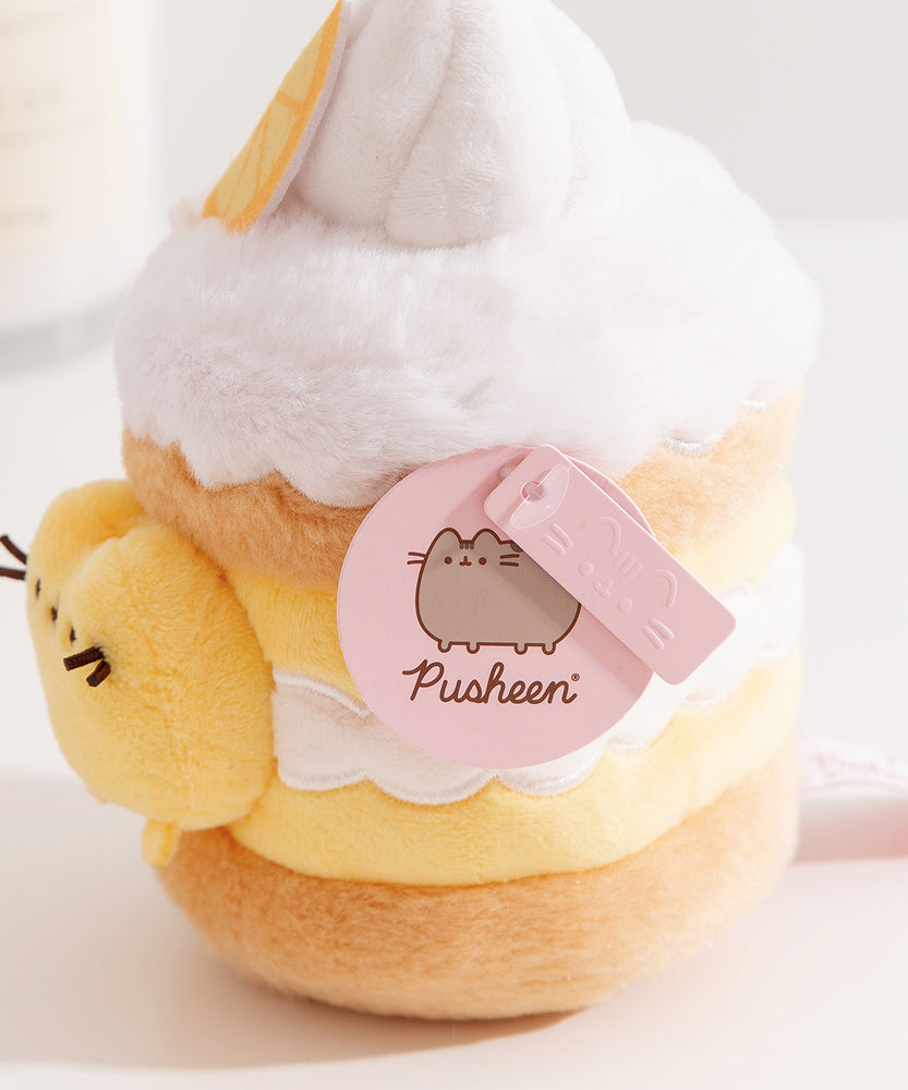 Close-up view of the Pusheen Label logo hangtags. The light pink tags feature the Pusheen the Cat logo on the circle sticker while Pusheen’s face is embossed in the rectangular shaped tag.  