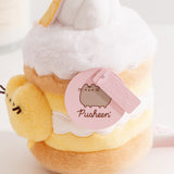 Close-up view of the Pusheen Label logo hangtags. The light pink tags feature the Pusheen the Cat logo on the circle sticker while Pusheen’s face is embossed in the rectangular shaped tag.  