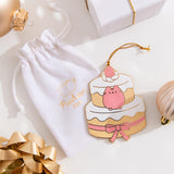 Strawberry cake ornament lies on top of its accompanying white storage bag. The white color of the bag matches the white icing on the cake. 