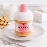Front view of the Strawberry Pusheen Cake Plush. The pink and white plush environment mimics the look of a layered strawberry cake with cut strawberries nestled inside the middle. 