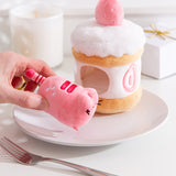 Model holds the removable Pusheen the Cat pink plush in front of the Plush environment. The light pink plush color matches the details on the Strawberry cake plush. 
