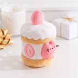 Side quarter view of the strawberry Pusheen plush. The cake plush has a light brown cake layer in the middle and at the bottom. The interior is a white icing layer with cut strawberries encircling the plush.  