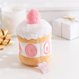 Side back view of the Pusheen Strawberry Cake Plush. The middle cake, icing, and strawberry embroidery continues all the way around the plush. 