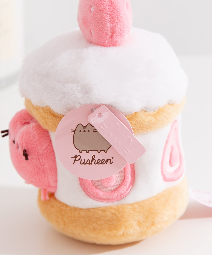 Close-up view of the Pusheen Label logo hangtags. The light pink tags feature the Pusheen the Cat logo on the circle sticker while Pusheen’s face is embossed in the rectangular shaped tag.  