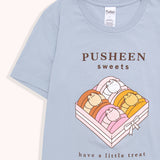 Close-up view of macaron graphic on the Sweet tee. The light pink box contains a brown chocolate, white and pink vanilla, toasted yellow caramel, and pink strawberry macarons. The light pink box is tied up with a white bow.