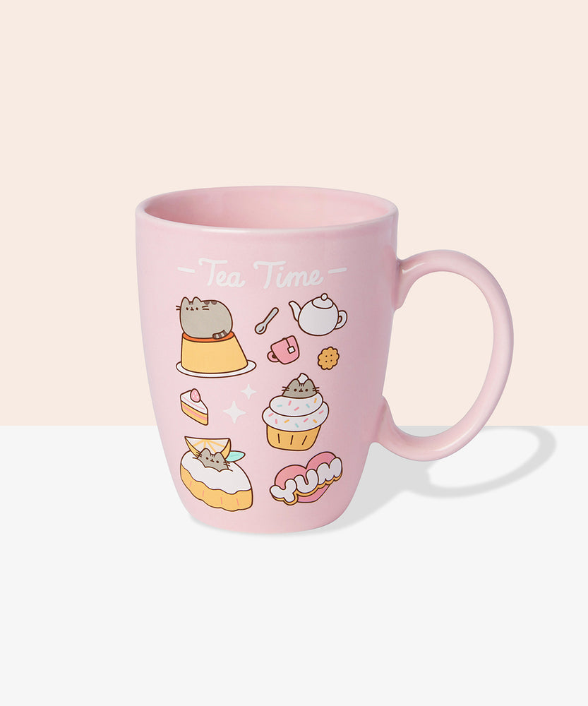 Back view of Pusheen Tea Time Mug. The outside of the mug features a pattern of Pusheen the Cat with various tea time accessories including a white tea kettle, spoon, and pink mug. Above the graphic pattern is the phrase "Tea Time" in white print.