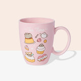 Back view of Pusheen Tea Time Mug. The outside of the mug features a pattern of Pusheen the Cat with various tea time accessories including a white tea kettle, spoon, and pink mug. Above the graphic pattern is the phrase "Tea Time" in white print.