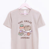 Pusheen Indoors Unisex Tee hangs on a light pink hanger in front of a white background. The printed graphic is placed in the front center of the shirt and covers most of the wearer’s chest. 