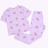 The Pusheen Twilight Pajama Set has a short sleeve light purple graphic pajama top and light purple lounge pants. The tee has an all-over graphic print of Pusheen surrounded by crescent moons, hearts, and stars. The lounge pants are covered in the same print as the top.  