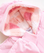 A close-up view of the hoodie hood interior. The sherpa has a checkered pattern printed using multiple pink hues. Next to the hood is the pink sleeve cuff which is ruched to stretch. 