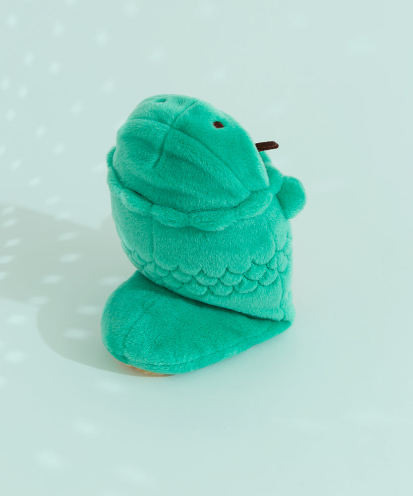 Back quarter view of plush. Pusheen wearing a green snake costume stands upright on two pudgy paws hidden beneath the snake tail costume.