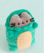 Top aerial view of Snake Pusheen plush with snake face hood off. Pusheen's fluffy grey ears and brown head stripes can be seen with the hood drawn back.