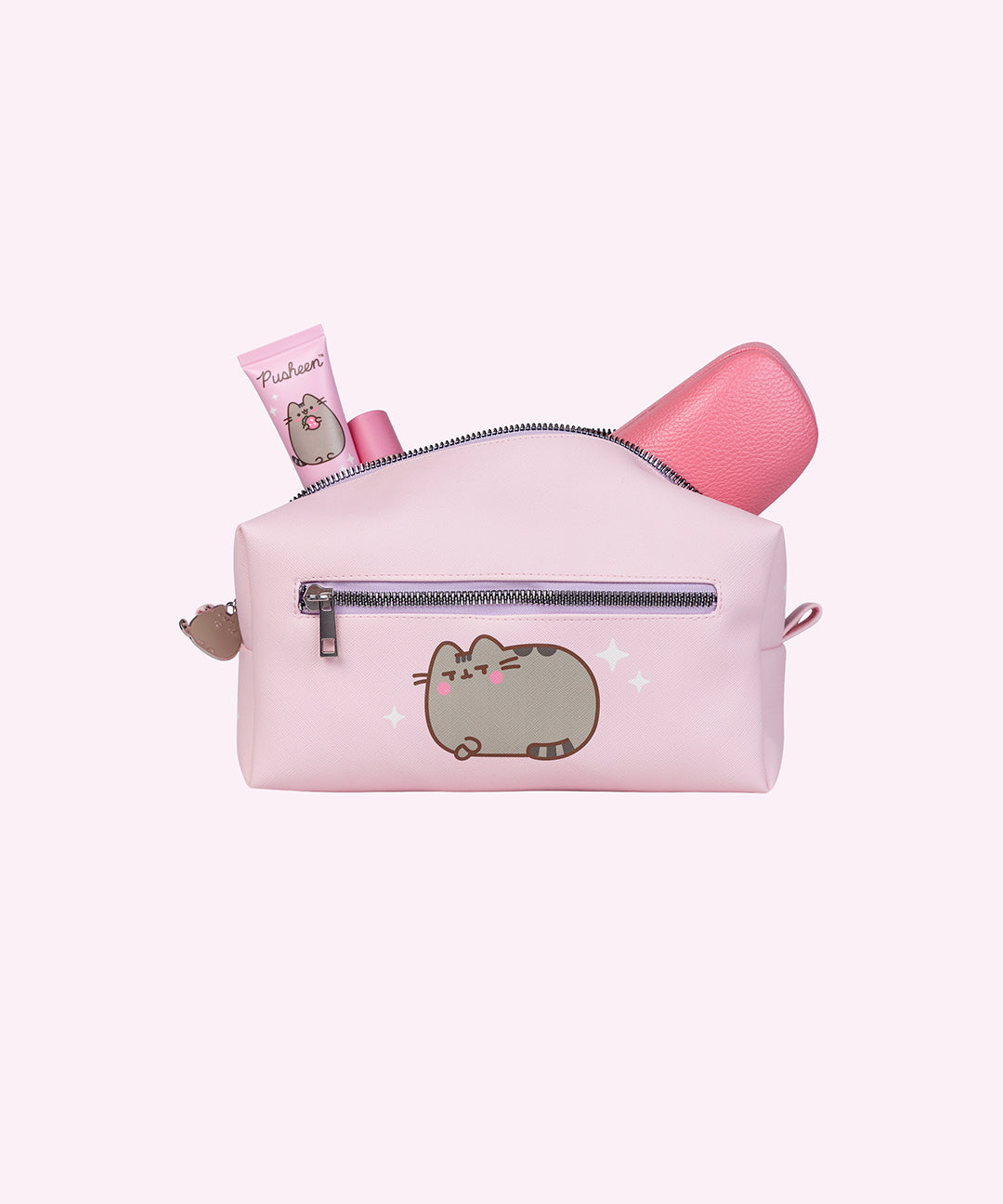 Back view of the Pusheen cosmetic bag. Various pink accessories stick out of the top of the bag. The back has an exterior zipper above a graphic of Pusheen blushing with her front paws crossed. 