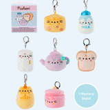 Pusheen the Cat has taken the form of seven miniature kitchen-inspired plushes. At the top left is the packaging box for the Pusheen’s Kitchen surprise plush. From left to right and top to bottom, the surprise plush are a cheese wedge, white milk jug, rectangular refrigerator, purple tea pot, white bead slice, honey jar, and a cooking pot. The bottom right corner has a circle with the words “1 Mystery Design” indicating eight possible miniature plush keychains are available. 