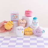 Model holds the honey jar kitchen keychain. The yellow plush features Pusheen the Cat taking the form of a golden honey jar. The plush has the word “honey” embroidered on the front of the plush. 