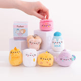 Model holds the top portion of the pot kitchen keychain. The pink plush features Pusheen the Cat taking the form of a cooking pot. The plush has Pusheen's face embroidered on the front of the plush. 