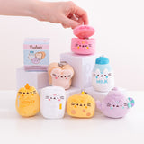Model holds the top lid open on the pot kitchen keychain. The pink plush is surrounded by a white and blue milk jug, cream and light brown, white bread slice, lilac tea pot, spotted cheese slice, white refrigerator, and yellow honey jar. 