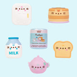 Pusheen's Kitchen Surprise Squishies surrounding the packaging capsule that each squishy comes in. The five squishys each stand around 2" tall.