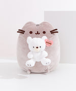 Front view of Pusheen x GUND Kai Bear Plush. The tabby cat sits upright holding a snow-white Kai bear, which is detailed with a cream-colored muzzle and embroidered paw pads.