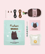 Contents included in the Intermediate Pip Crochet Kit. The kit includes a needle, two plastic eyes, two clear buttons, all necessary yarn colors, a custom mint green crochet hook, stuffing, and a how-to guide. 