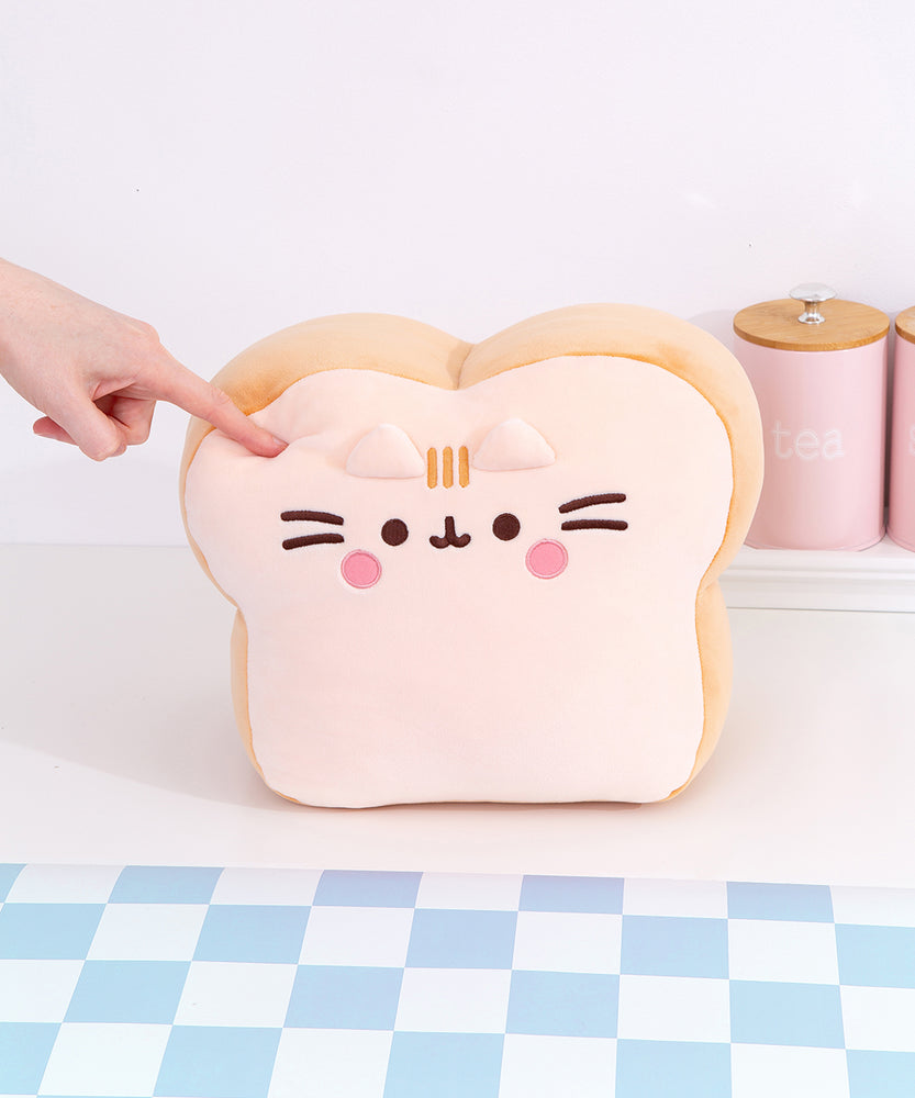 Model pokes the Pusheen's Kitchen White Bread Squisheen to show the squishy texture of the plush.