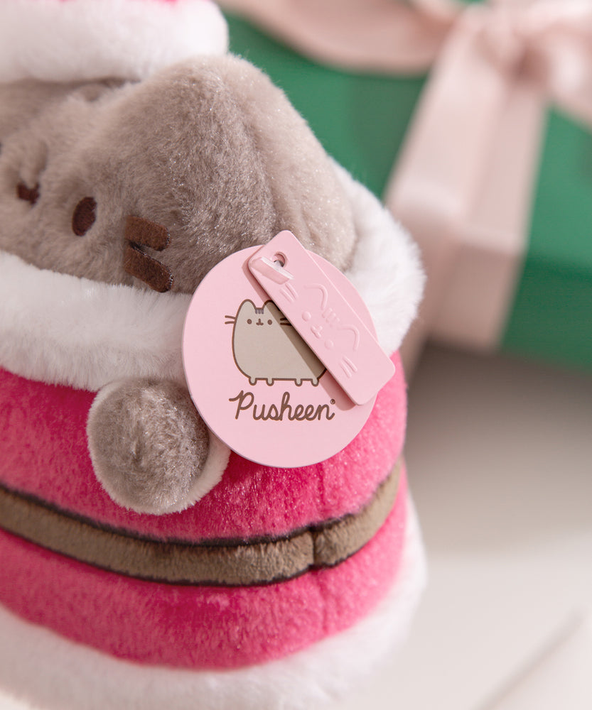 Close-up of the Pusheen and Pusheen Label Exclusive pink tags attached to the white collar of the plush.