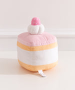 Back view of the Strawberry Sponge Cake plush. The cake plush has light pink icing, light yellow cake layers, and white cream extending around the back of the plush.