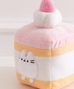 Close-up of the Pusheen plush on the Cake Squisheen. Pusheen's eyes, nose, and whiskers are embroidered in black while her three head stripes are a medium pink embroidery color.