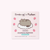Front view of the palette. Pusheen the Cat is shown sleeping on a white cloud surrounded by pink strawberries and white sparkles. Printed on the top is The Creme Shop and Pusheen logos and on the bottom shows that the palette is cruelty-free and vegan.