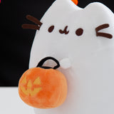 Close-up view of the side of the Boosheen plush. The white ghost plush has 3D brown whiskers that extend off the plush toy. Pusheen's two front paws extend off the front of the plush and hold the trick-or-treat candy pail.