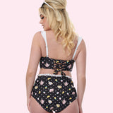 Model shows off the back of the swimsuit. The top features a corset-style tie back while the bottoms have a high-waisted retro-fit.