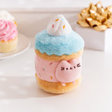 Alternate side quarter view of the Pusheen Sweets Sprinkle Cake Plush Environment. The blue, pink, and brown plush has a removable miniature plush of Pusheen the Cat.  