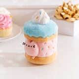 Side view of the Sprinkle Cake Plush. The removable interior plush rests in front of the cake environment. The little pink plush fits inside the front hole of the cake plush. 
