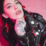 Bishop Briggs wearing a black leader jacket with the pins attached to it’s collar.