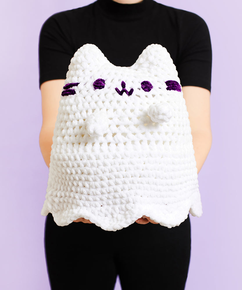 A completed Crochet Boosheen plush being held by a model. 