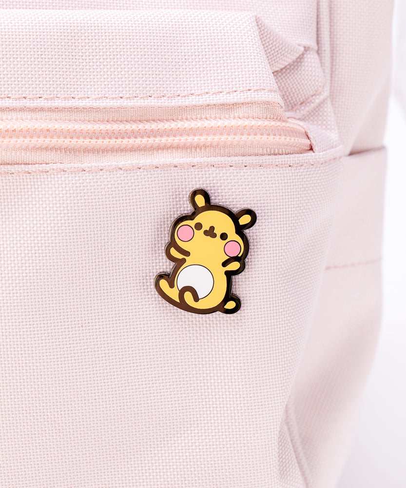 The Cheek pin attached to a pink backpack.
