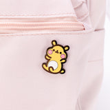The Cheek pin attached to a pink backpack.