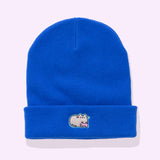 Front view of the Gaming Pusheen Knit Hat. The royal blue beanie lays on a light colored surface. On the folded edge of the beanie features an embroidered Pusheen the Cat with a pink gaming controller. 
