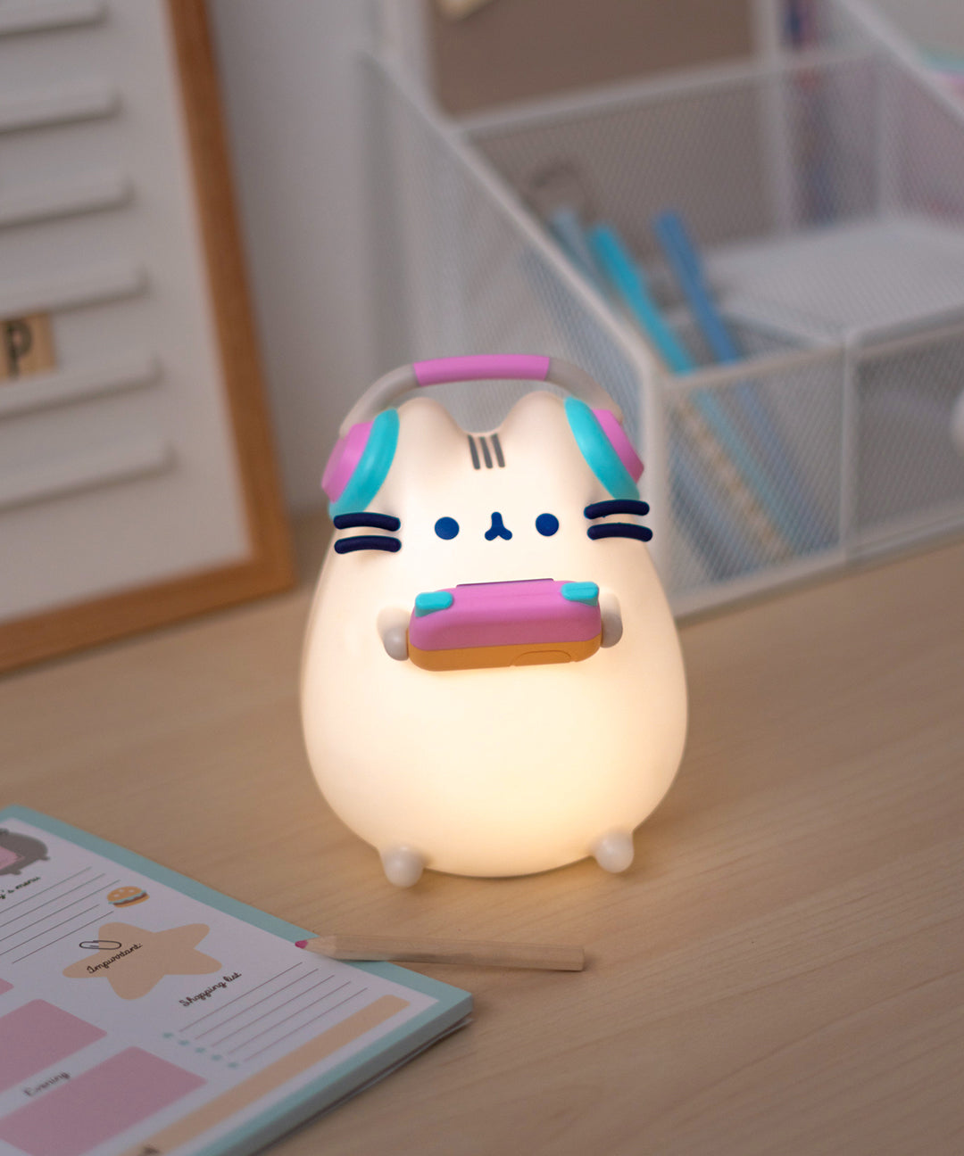 Front view of the gaming lamp lit up. The grey cat body emits a light-yellow hue when turned on.  