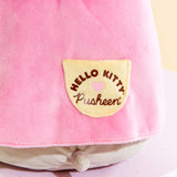 Close up of the Hello Kitty x Pusheen collaboration logo screen printed on the dress pocket. The logo features Hello Kitty's logo curved over a pink heart, with Pusheen's logo underneath the heart.