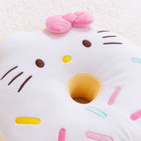 Close-up view of the Hello Kitty side of the Donut Plush. In this view, you can see the embroidered details of Hello Kitty’s facial features and her multicolored sprinkles. The sides of the donut plush are yellow.  