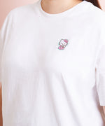A model wearing a white shirt in a quarter view with the Hello Kitty patch above the right breast. The patch makes the shirt look like an embroidered tee.