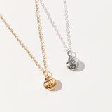 Gold and Silver charm necklaces next to one another. The charm features Pusheen sticking her head out of the top of a jack-o-lantern.