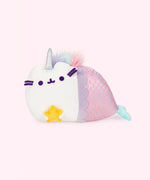 A white Pusheen with a pink mermaid tail with a purple scallop rim and reflective green scales and a green fin, sitting on her side while holding a star in her paws. Mermaid Pusheenicorn has sea green head stripes, a unicorn horn, and a purple, green and pink fluffy mane that ends right as her mermaid tail begins. 