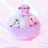 The Mini Pastel Pusheen riding their space ship across the holographic sea. The Mint and Pink Pusheen poke their heads out from the windows, while the lilac Pusheen sits on top of the ship. 