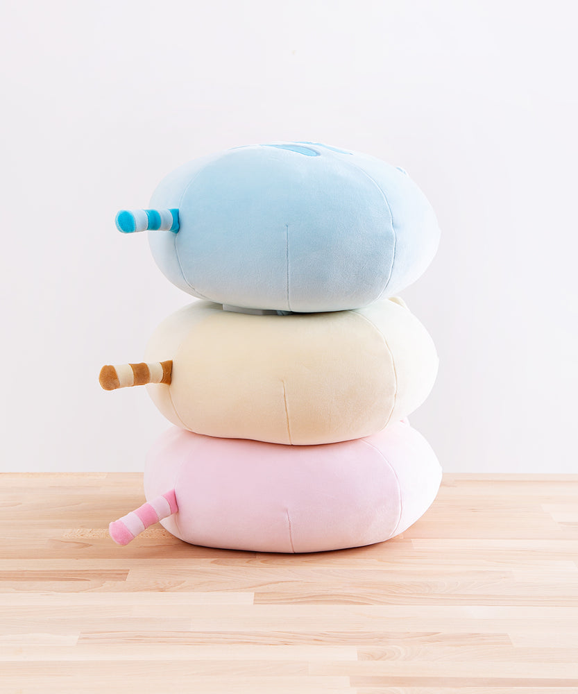 Quarter back view of the three Round Squisheen Plush stacked on top of one another, sitting on top a wooden floor in front of a white background. All plush have a striped tail in the middle of their butts which point straight out and line up perfectly with one another.