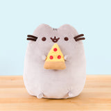 Pusheen sitting upright, mouth open, her two top nub paws holding a plush pepperoni pizza slice, and her bottom nub feet rest at the bottom.