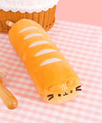 Top view of the bread plush. The golden-colored plush has five light cream lines across the top of the plush body to mimic bread bake lines. 
