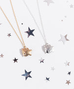 Front view of Pusheen Celestial Charm Necklace. On the left is the gold vermeil finish of the charm necklace and on the right is a sterling silver finish. The necklace shows Pusheen the Cat holding an enlarged star in front of her body. 